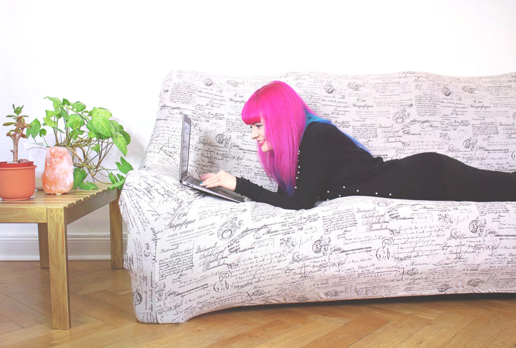 Lucia Clara Rocktäschel mit Laptop auf dem Sofa liegend.