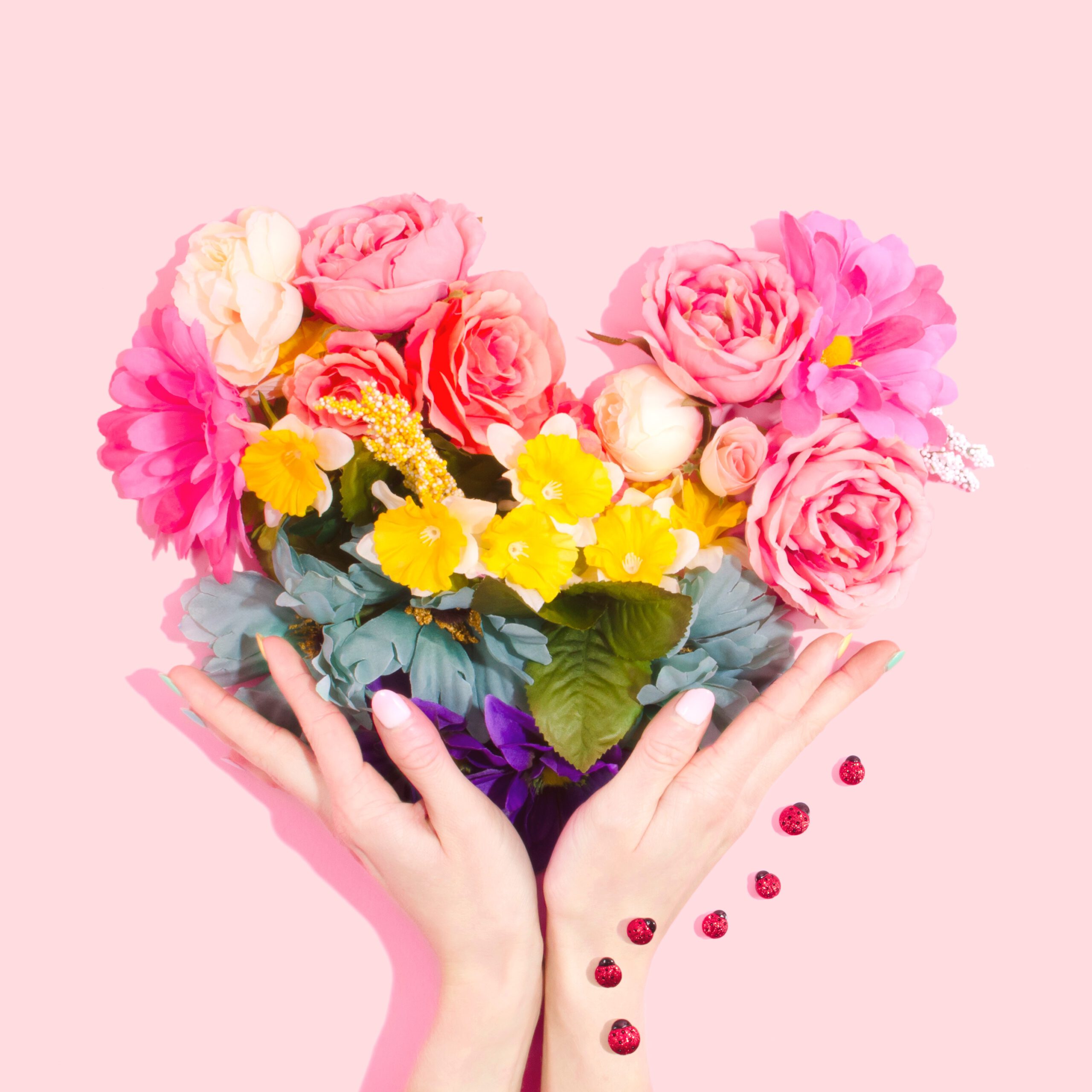 Herz aus Blumen in Regenbogenfarben